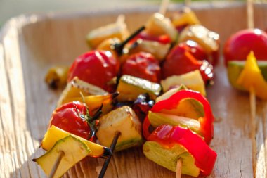 Ahşap bir tabak, soğan biber kabak domates kavrulmuş barbekü bir bitki salamura Sında ızgara sebze şişler