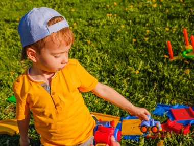 çocuk oyuncak araba yeşil çimenlerin üzerinde çalış.