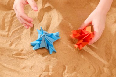 El yapımı origami kağıt, sahilde kum, konsept başlatmak roket oynamaktan mutlu çocuk çocuk