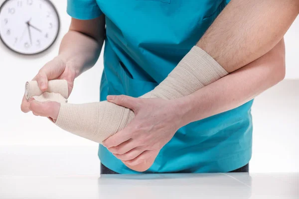 Gros plan du médecin masculin bandage du pied de la patiente — Photo