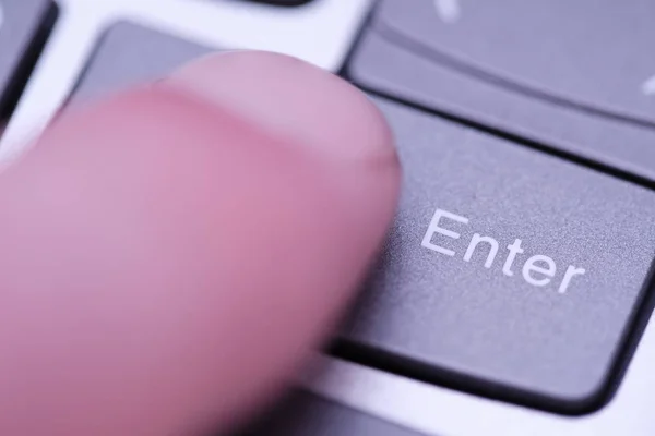 Closeup finger presses the key on of laptop keyboard illumination, backlit keyboard