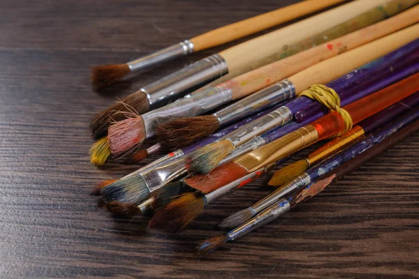 Artist paint brushes on wooden background — Stock Photo, Image