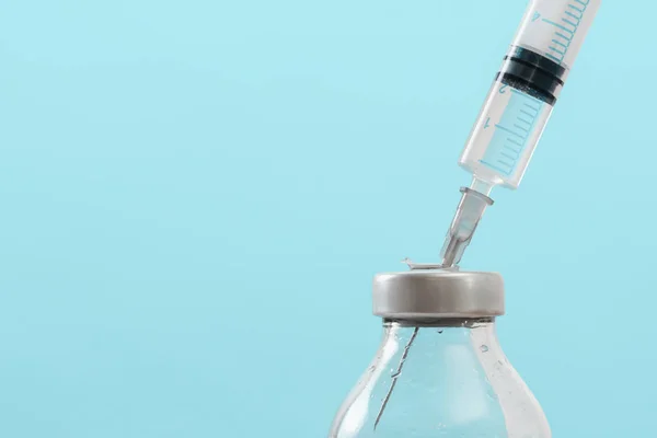 Geneeskunde in flesjes en spuiten, klaar voor de vaccin injectie, behandeling van kanker, pijnbehandeling op blauw — Stockfoto