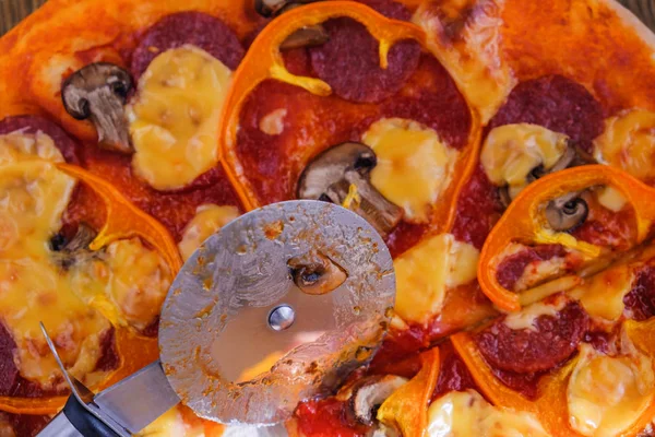 Порізка піци пепероні на скибочках з ножем . — стокове фото