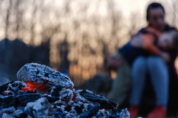 Mutter und Sohn sitzen abends am Feuer bei einem Picknick — Stockfoto