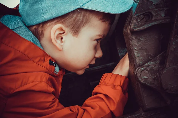El niño está jugando en un gran cañón pesado de los tiempos de la Segunda Guerra Mundial en el monumento — Foto de Stock