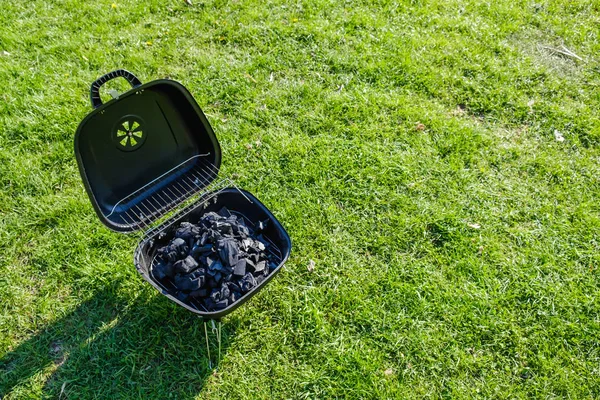 Smokehouse churrasqueira fica na grama em um jardim de verão. Espaço de cópia vista superior . — Fotografia de Stock