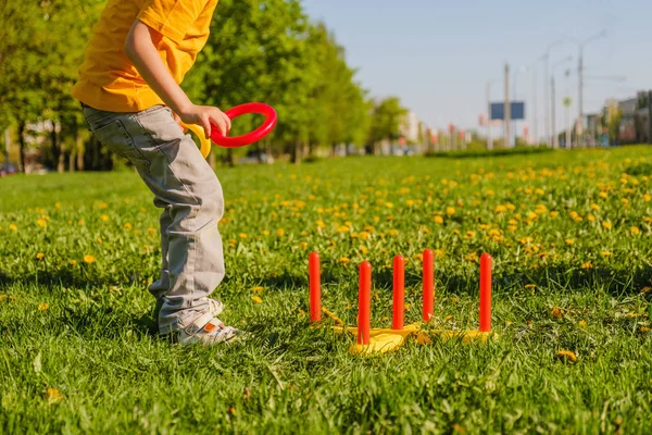 Маленький хлопчик грає. Кільце кидає літню гру на зелений газон на сонці — стокове фото