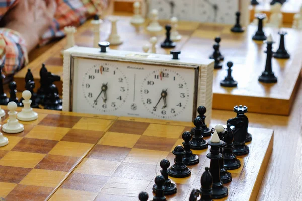 Parçalar ve satranç turnuvası ile bağlantılı olarak ahşap masa saati ile satranç masası. — Stok fotoğraf