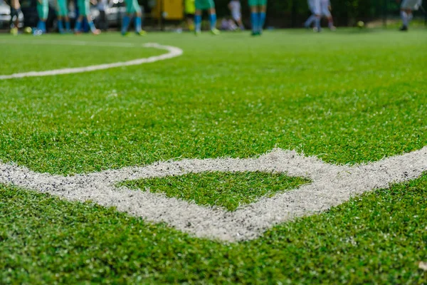 Weißer Streifen auf künstlichem grünen Fußballfeld von der Seite. — Stockfoto