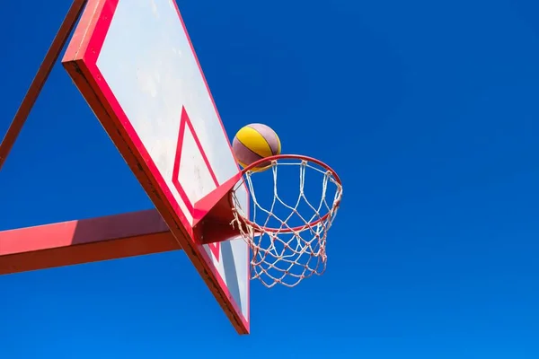 Street basketball έννοια, μπάλα στο μπλε φόντο του ουρανού. — Φωτογραφία Αρχείου