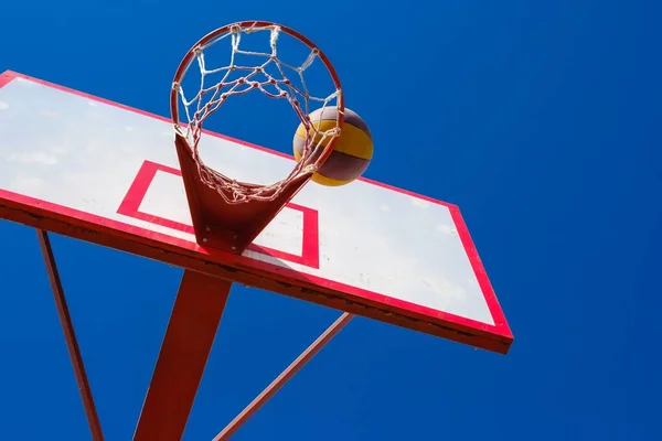 Street basketball έννοια, μπάλα στο μπλε φόντο του ουρανού. — Φωτογραφία Αρχείου