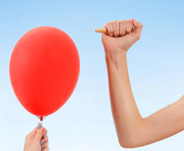 Mão segurando agulha perto do balão. isolado em branco. Conceito de perigo . — Fotografia de Stock