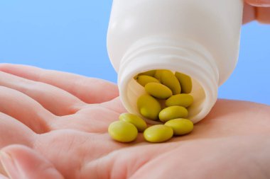 Kapalı kadın hapları şişeden boşaltıyor. İlaç ve sağlık hizmetleri kavramı.