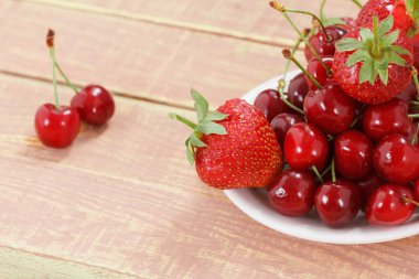 Meyve arka planı, kiraz ve çilek ahşap masada. Yukarıdan kopyalama alanı ile görüntüle