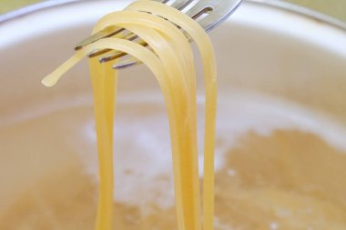 Tavada spagetti kaynayan suda pişiyor, makarna pişiriyor, şehriye pişiriyor.