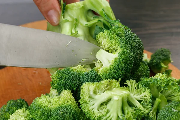 Stock up on winter food. Chef cutting fresh green broccoli cooking.