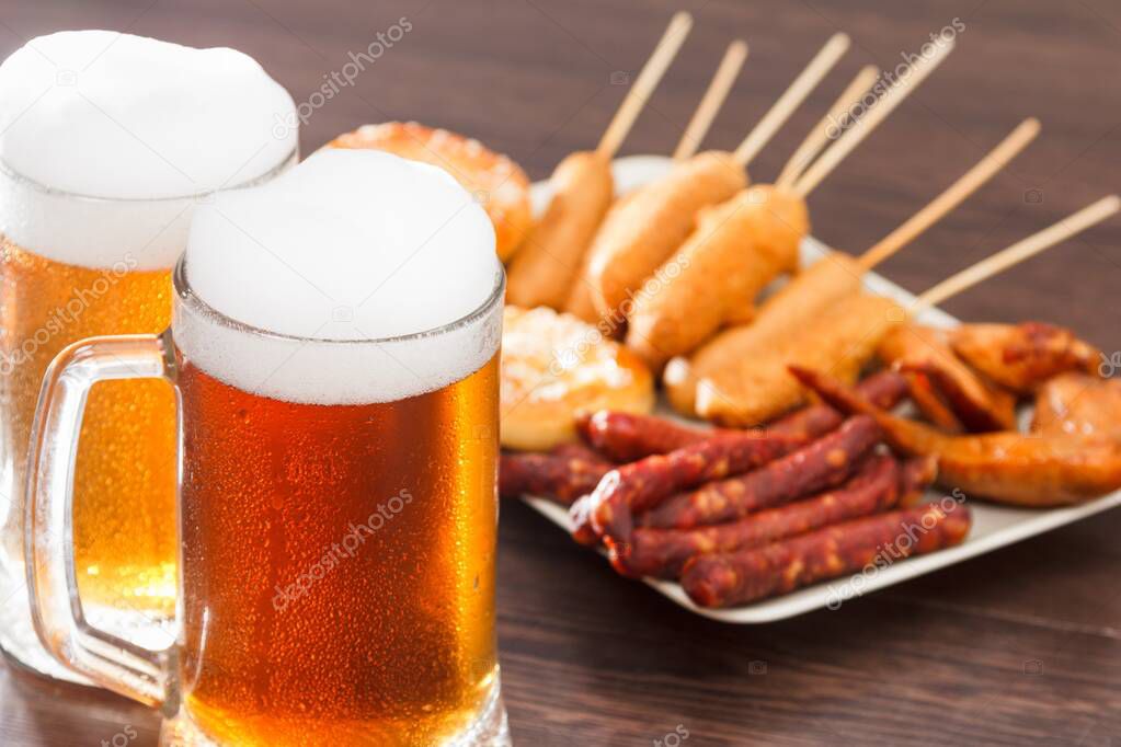 Beer glass alcohol drink with food sausage and meat, snack picnic.