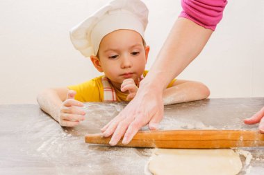 Çocukların ellerinin hamur yoğuruşuyla ilgili detaylar. Neşeli aşçı şapkalı çocuk burrito ya da pizza hazırlar.