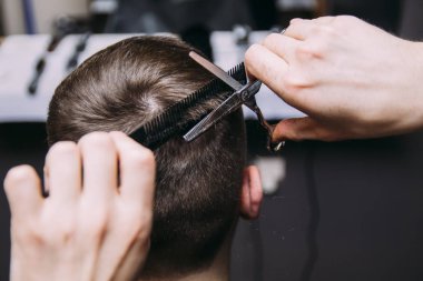 Ana kesim saç ve sakal Berber Dükkanı'nın adamlarından, Kuaför saç modeli için genç bir adam yapar.