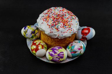 Kutlama pastası ve güzel yumurtalar Kutsal Paskalya için siyah arka planda.