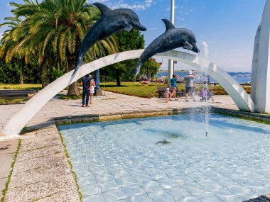 Yaz manzarası, palmiye ağaçları ve deniz kıyısında bir çeşme..