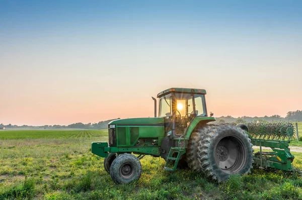 Трактор в полі на Меріленд хуторі біля захід сонця — стокове фото