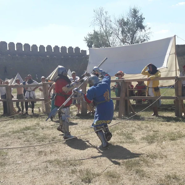 Uomini non identificati in armatura che dimostrano abilità di combattimento durante la ricostruzione del torneo vicino al castello — Foto Stock