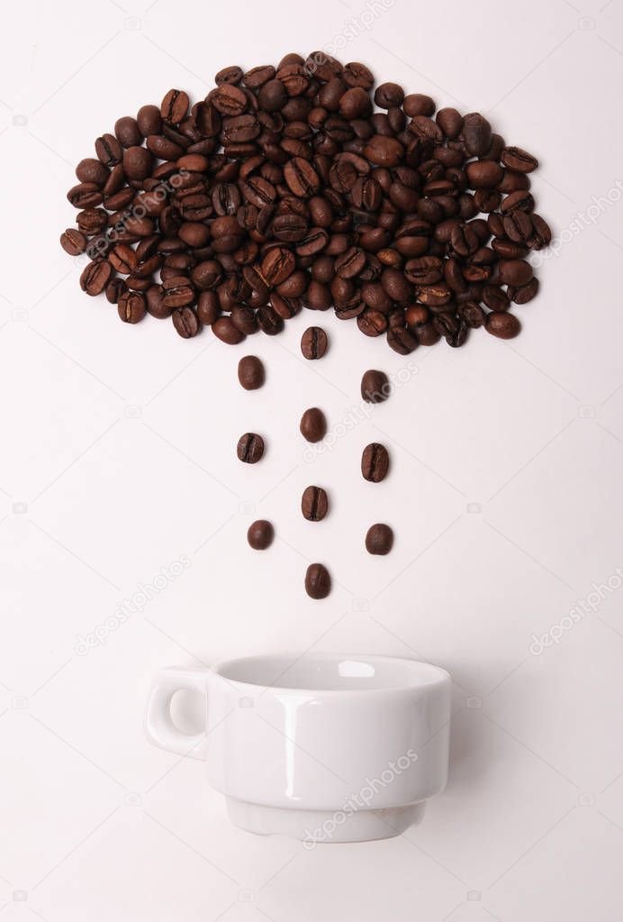 Coffee beans in shape of cloud pouring rain in a white cup on white background