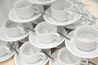 Beyaz bardak ve kaşık ile daireler birbirine bağlı bir piramit şekli bulunmaktadır