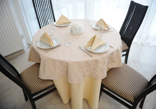 Table in the restaurant served for four persons. Bright interior — Stock Photo, Image