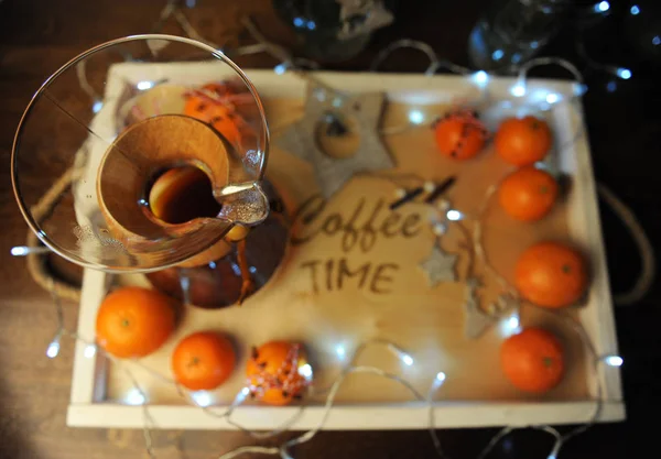 Mandarins, coffee, decoration and garland on a wooden tray with engraved "coffee time". Holiday atmosphere, holiday, Christmas. — Stock Photo, Image
