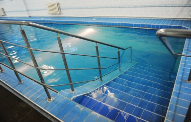 Mavi bir havuzda merdivenlerden inmek