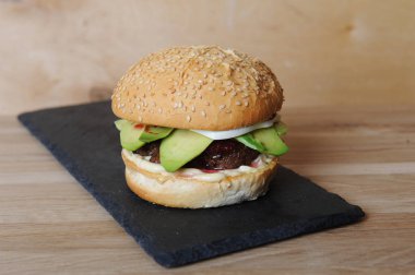 Burger closeup kayrak Bankası, cam ve çatal bıçak takımı ahşap bir gemide görev yaptı.