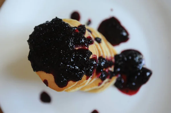 Hemmagjord söta pannkakor med bär sylt på en vit platta, närbild, ovanifrån — Stockfoto