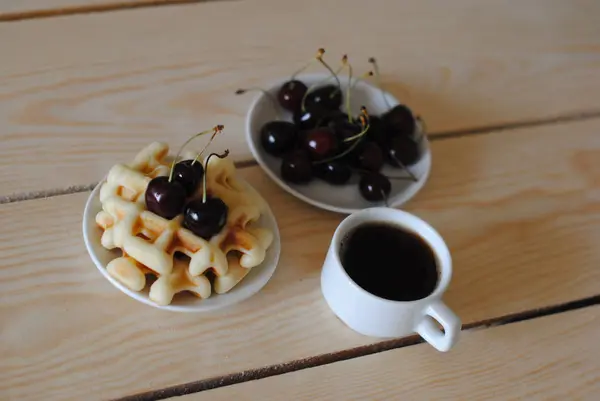 Waffles, cereja e café na mesa de madeira — Fotografia de Stock