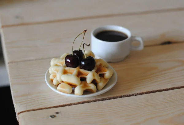 Wafels, cherry en koffie op de houten tafel — Stockfoto