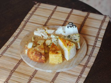 Peynir tabağı. Mindere yuvarlak ahşap tahta üzerinde çeşitli salamura peynir