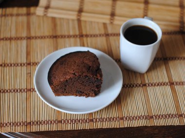 Bir mat üzerinde beyaz bir kase çikolata kek ve kahve bir parça. Close