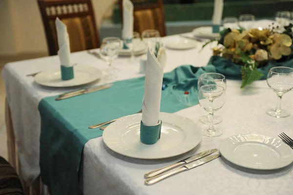 Tafel in het restaurant geserveerd met turquoise tafelkleed — Stockfoto