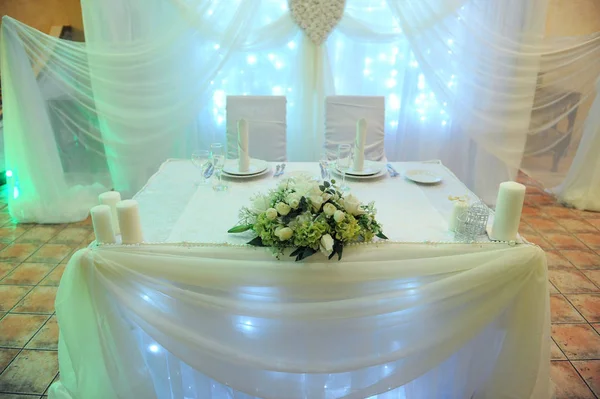 Fehér asztal dekoráció a nászéjszakára, az étteremben. Háttérvilágítás. Szív kárpit — Stock Fotó