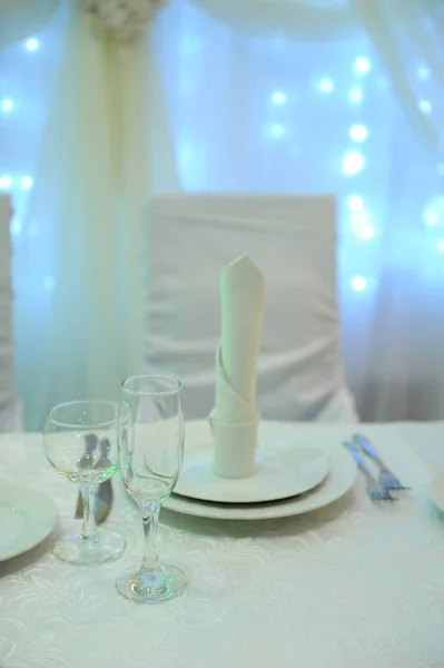 Weiße Tischdekoration für das Brautpaar im Restaurant. Gegenlicht. Herztuch — Stockfoto