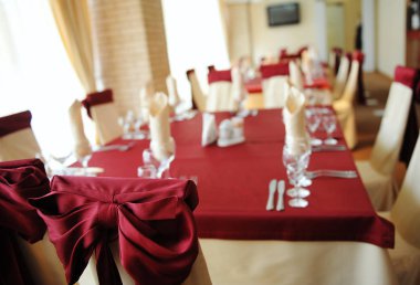 Tablo bir restoranda servis. Krem ve kahverengi renkleri. Yay perdelik sandalyelere