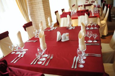 Tablo bir restoranda servis. Krem ve kahverengi renkleri. Yay perdelik sandalyelere