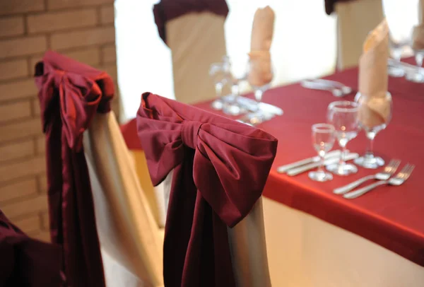 Serviert Tisch in einem Restaurant. Creme und kastanienbraune Farben. Verbeugung auf Stühlen. Nahaufnahme — Stockfoto