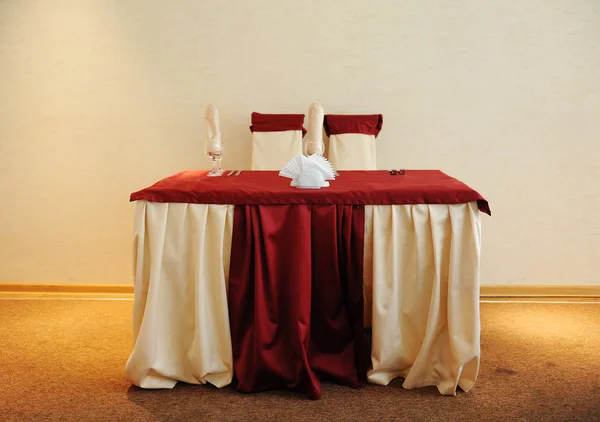 Mesa servida en un restaurante. Colores crema y granate. Arcos con cortinas en sillas — Foto de Stock