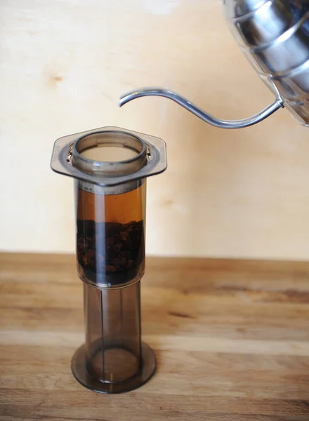 Objects for alternative coffee brewing on a wooden background.. specialty coffee. Stream of water pours from drip maker — Stock Photo, Image