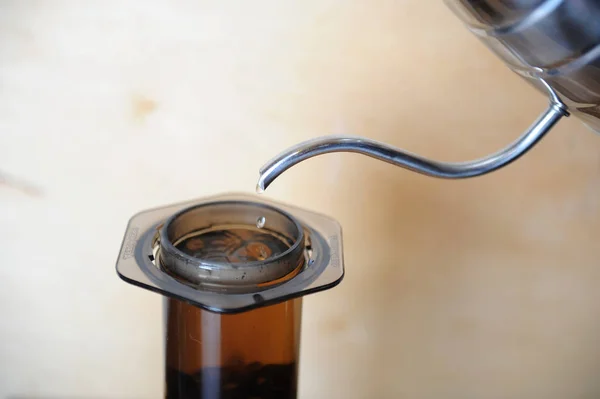 Objects for alternative coffee brewing on a wooden background.. specialty coffee. Stream of water pours from drip maker — Stock Photo, Image