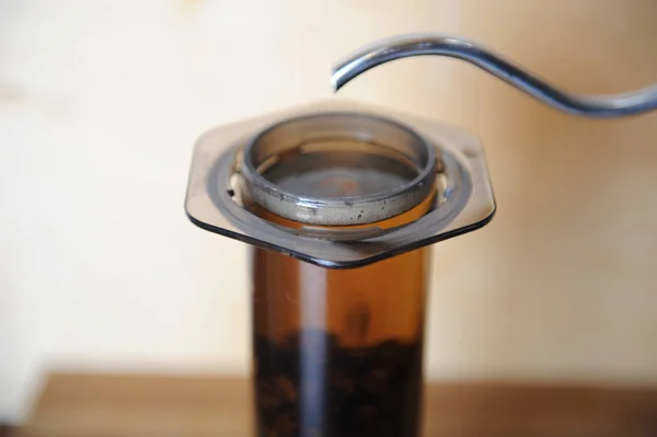 Objects for alternative coffee brewing on a wooden background.. specialty coffee. Stream of water pours from drip maker — Stock Photo, Image