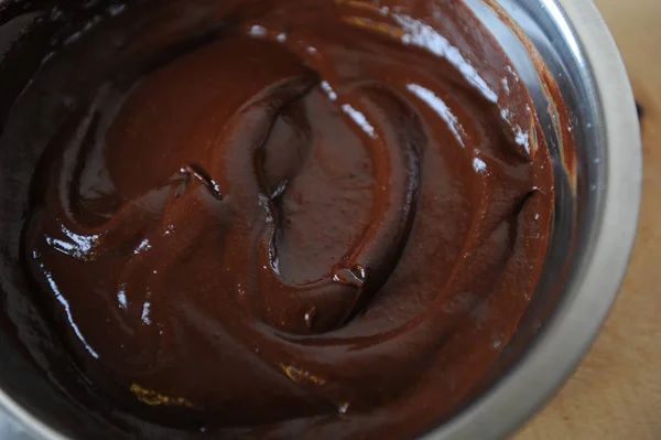 Die Textur der geschmolzenen Schokolade. in einer Stahlschale. Nahaufnahme — Stockfoto